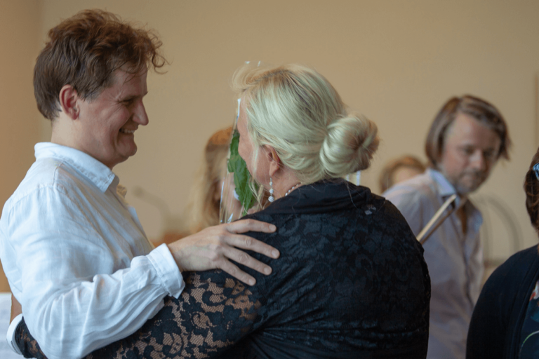 Talkoolainen kukittaa taiteilijaa