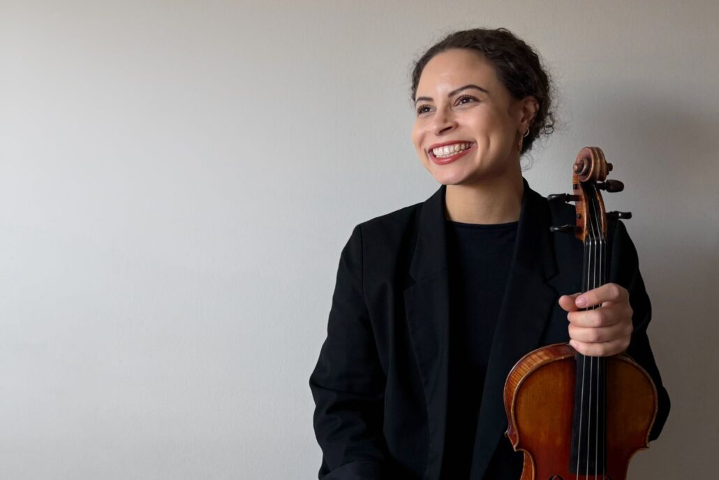 hymyilevä nainen viulu kädessään