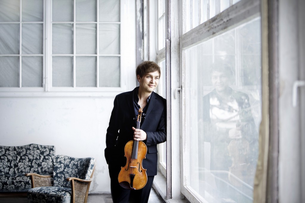 hymyilevä mies nojaa ikkunaan viulu kädessään