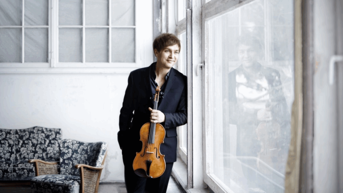 hymyilevä mies nojaa ikkunaan viulu kädessään